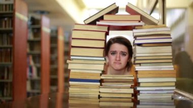 kitap evi-şekilli yığını bakan hüzünlü kız öğrenci