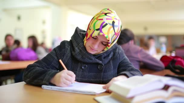 Feliz joven estudiante leyendo libro en la biblioteca — Vídeos de Stock