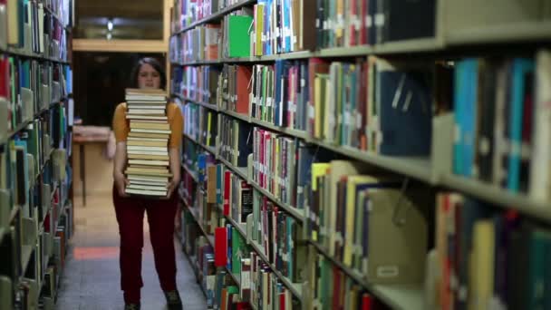 Distressed female student wandering between shelves — Stock Video