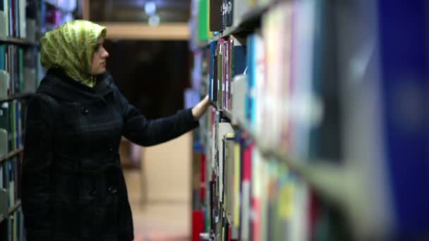 Female student wandering between shelves — Stock Video