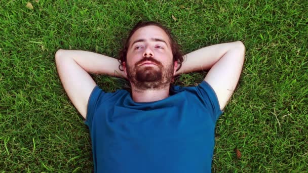 Młody facet śpi na trawie — Wideo stockowe