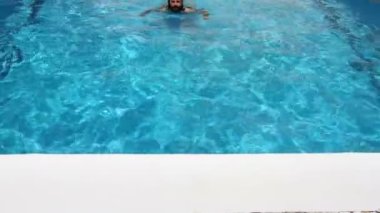 Yüzme havuzunda yüzerek adam