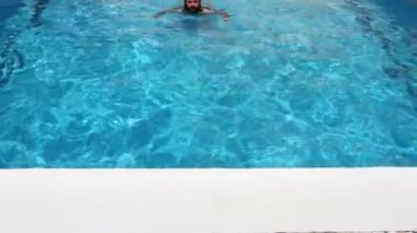 Yüzme havuzunda yüzerek adam