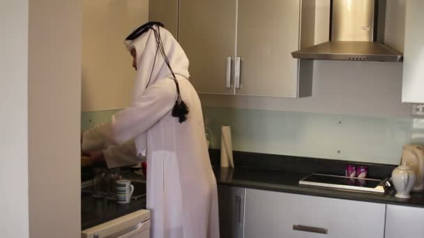 Saudi Arabian man washing dishes at home — Stock Video