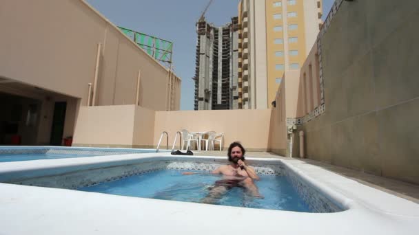 Мужчина в бассейне на крыше квартиры в Бахрейне — стоковое видео