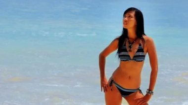 Seksi Asyalı kız egzotik plajda güneşlenirken ve bronzlaşma