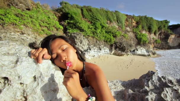 Uwodzicielska seksowna dziewczyna niegrzeczny lizać lizaka na plaży — Wideo stockowe