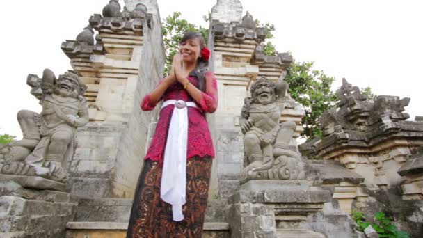 Chica balinesa saludando con ambas manos en templo uluwatu, bali — Vídeos de Stock