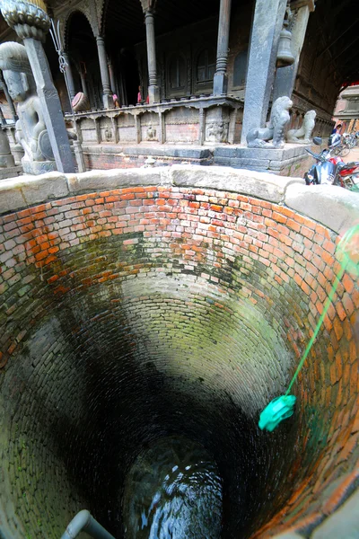 Puxando recipientes de água do poço — Fotografia de Stock
