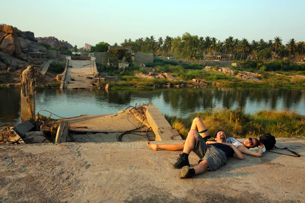 Casal deitado junto ao rio — Fotografia de Stock