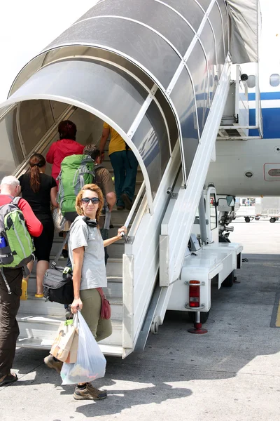 Passagiers lopen op instapweigering brug op luchthaven jetway — Stockfoto