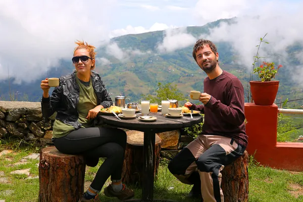 Casal de turistas tomando café da manhã nas montanhas himalaias Imagens Royalty-Free