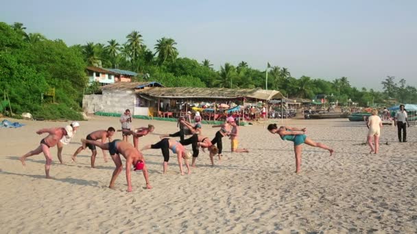 People practicing yoga on beach — Stock Video