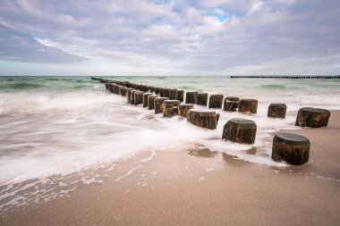 Fırtınalı bir günde Baltık Denizi kıyısında Groyne 'ler.