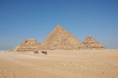Giza Piramitleri 'nin yakınındaki at arabaları. Menkaure ve piramitler Çölden Queens görünüyor
