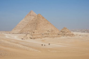 Khafre, Menkaure ve Queens Piramitlerini çölden izleyin. Çerçevede birkaç at ve deve binicisi var..