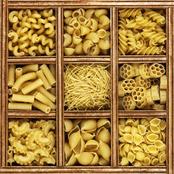 Verschillende soorten Italiaanse pasta in houten kist catalogus — Stockfoto