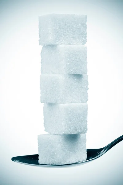 La pila de los terrones de azúcar en la cuchara. aislado en blanco —  Fotos de Stock