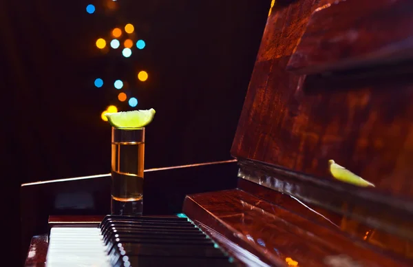 Glass with tequila on a piano — Stock Photo, Image