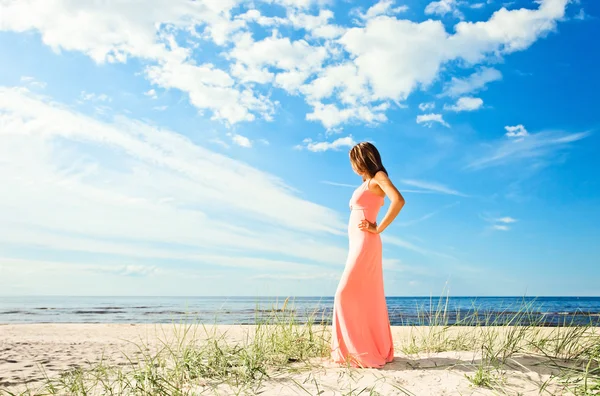 Mädchen in rosa Kleid an der Küste — Stockfoto