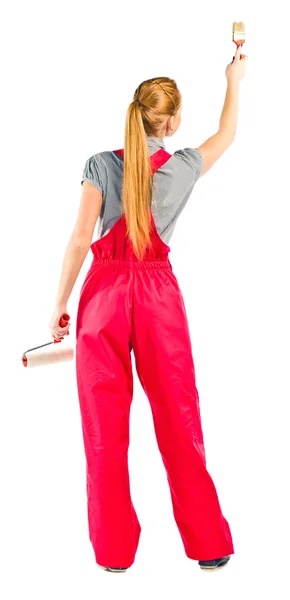 Young woman in red overalls with painting tools — Stock Photo, Image