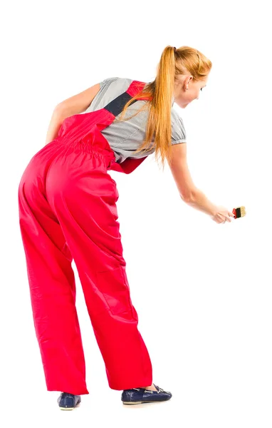 Young woman in red overalls with painting tools — Stock Photo, Image