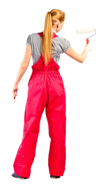 Young woman in red overalls with painting tools — Stock Photo, Image