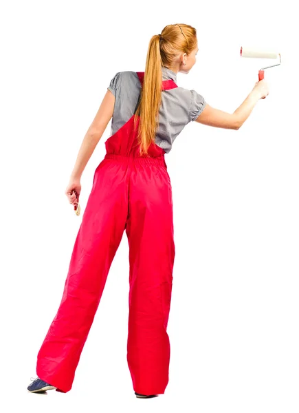 Young woman in red overalls with painting tools — Stock Photo, Image