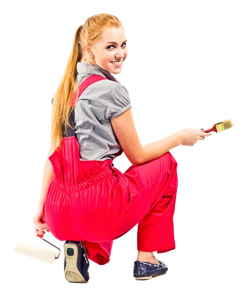 Young woman in red overalls with painting tools — Stock Photo, Image