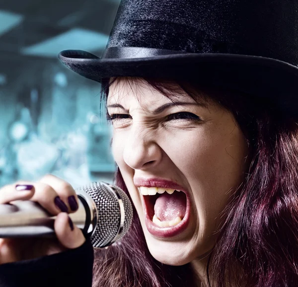 Fille avec microphone en chapeau noir — Photo