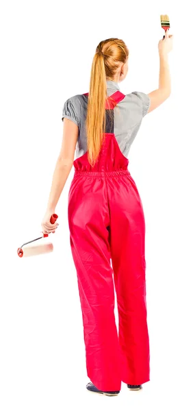 Молодая женщина в красном комбинезоне с инструментами для рисования — стоковое фото