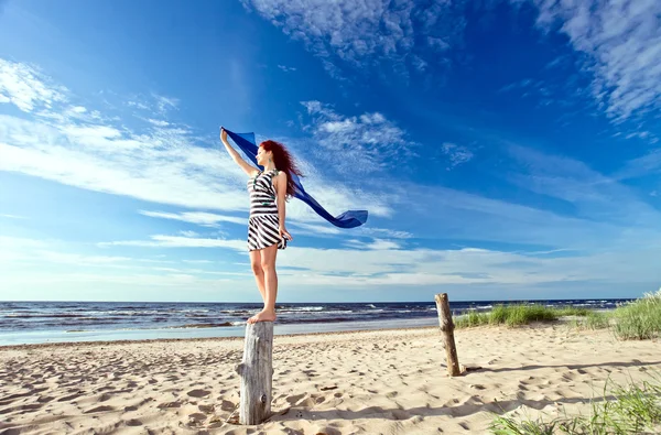 Menina em vestido listrado em uma praia — Fotografia de Stock