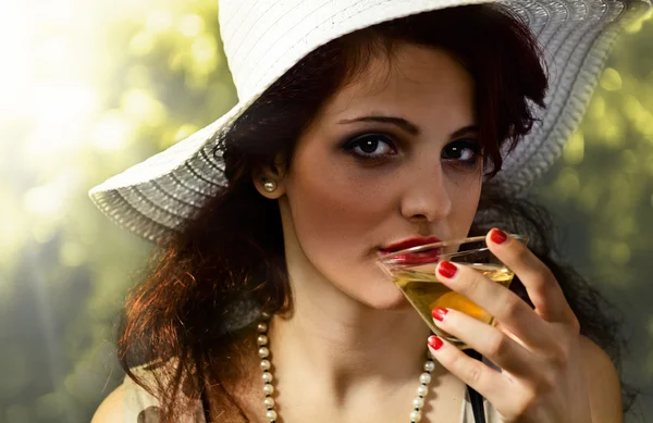 Vrouw in witte hoed met cocktail — Stockfoto