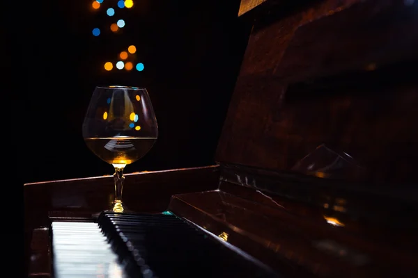 Brandy on a old piano — Stock Photo, Image