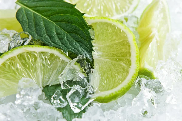 Slices of a lime and leaves of mint — Stock Photo, Image