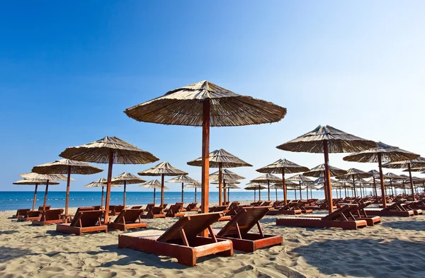 Tumbonas y sombrillas en la playa — Foto de Stock