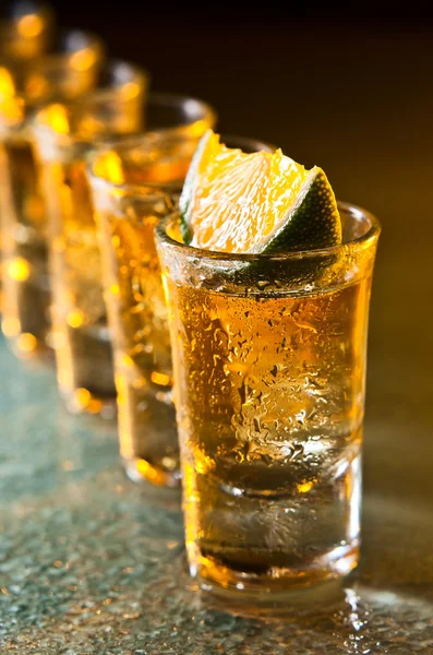 Tequila e lime su tavolo di vetro — Foto Stock