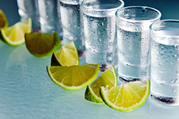 Tequila and lime on glass table — Stock Photo, Image