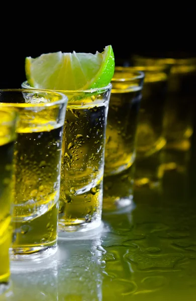 Tequila en kalk op glazen tafel — Stockfoto