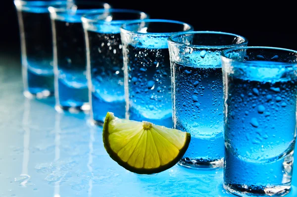 Tequila e lime su tavolo di vetro — Foto Stock