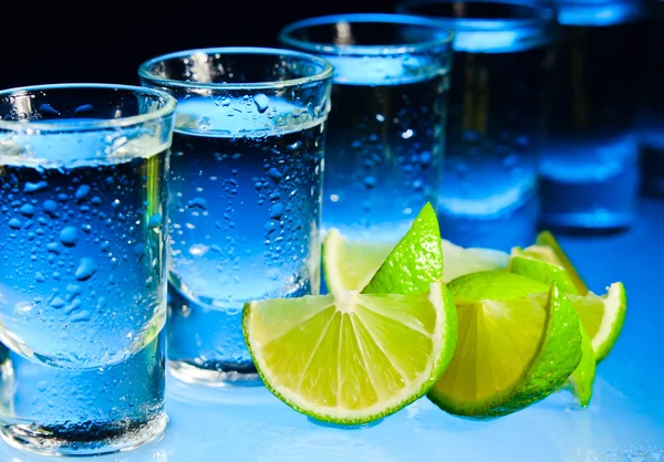 Tequila e lime su tavolo di vetro — Foto Stock