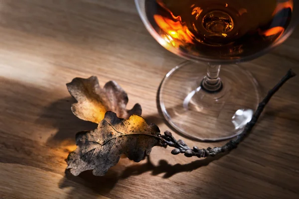 Brandy en gedroogde eikenbladeren — Stockfoto