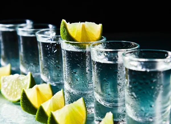 Tequila and lime on glass table — Stock Photo, Image