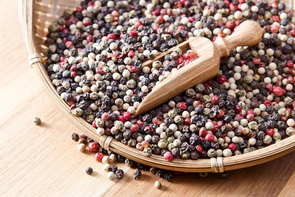 Peppercorns on wooden table — Stock Photo, Image