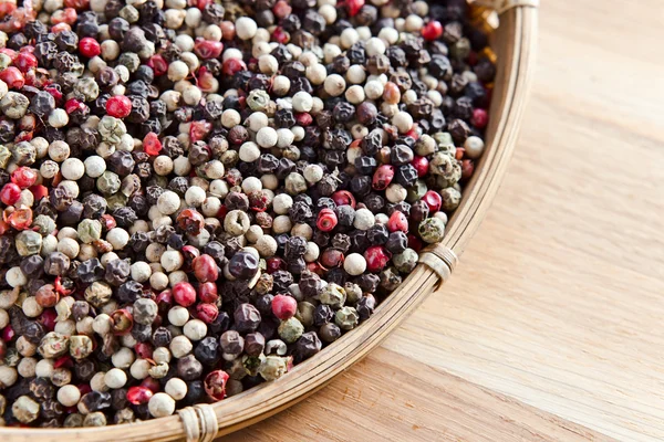 Peppercorns on wooden table — Stock Photo, Image