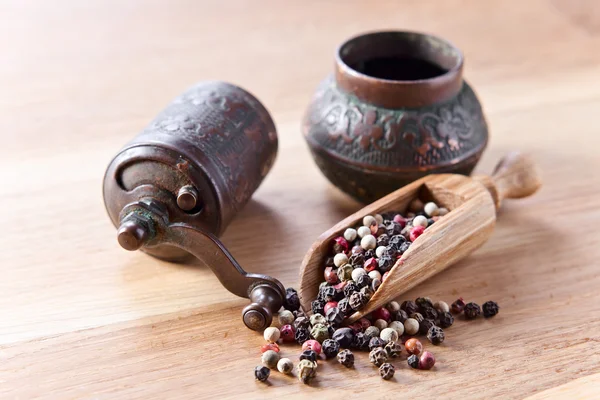 Peppercorns on wooden table — Stock Photo, Image