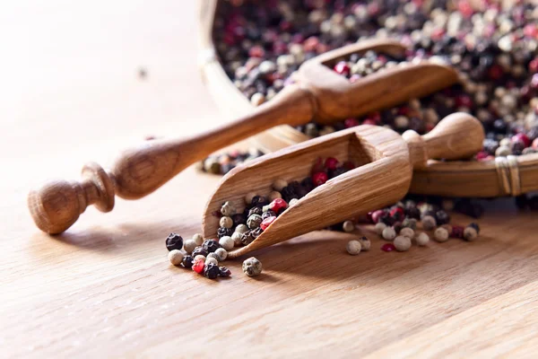 Peppercorns on wooden table — Stock Photo, Image