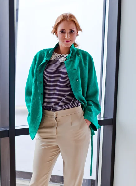Jonge mooie vrouw in groene jas — Stockfoto