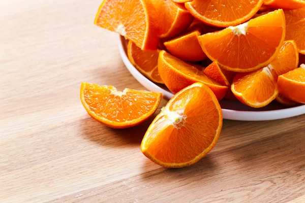 Cut tangerines on wooden table — Stock Photo, Image