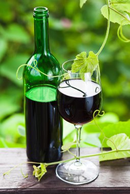Kırmızı şaraplı şişe ve bardak.